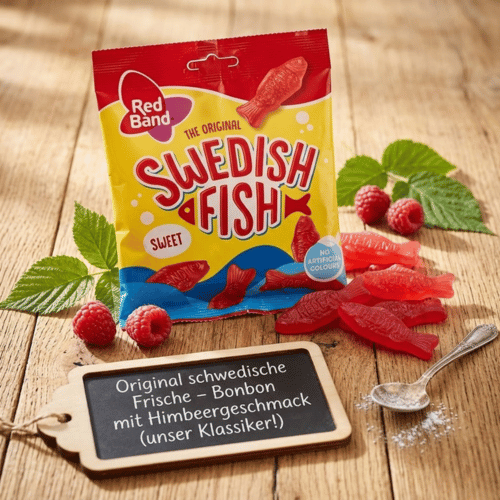 Produktinszenierung der Red Band Swedish Fish 100g Packung auf rustikalem Holzgrund, dekoriert mit frischen Himbeeren und einer Schiefertafel, die den klassischen Himbeergeschmack betont.