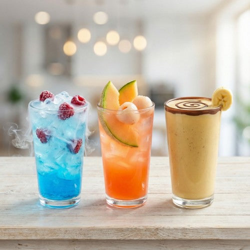 Drei Trend-Getränke 2026 im Glas: Eisiger Energy-Drink, exotische Fanta Melone und Banane-Schoko-Drink auf Holztisch