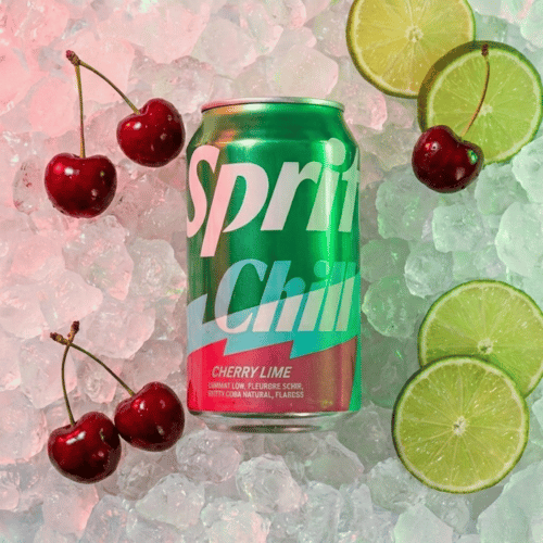 Eine grüne Dose Sprite Chill Cherry Lime liegt in einem Bett aus zerstoßenem Eis. Umgeben ist die Dose von frischen, dunklen Kirschen und saftigen Limettenscheiben. Das Licht ist in einem sanften Pink-Ton gehalten, was die Kirsch-Note unterstreicht.